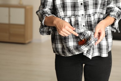 Photo of Woman showing sauce stain on her shirt indoors, closeup. Space for text