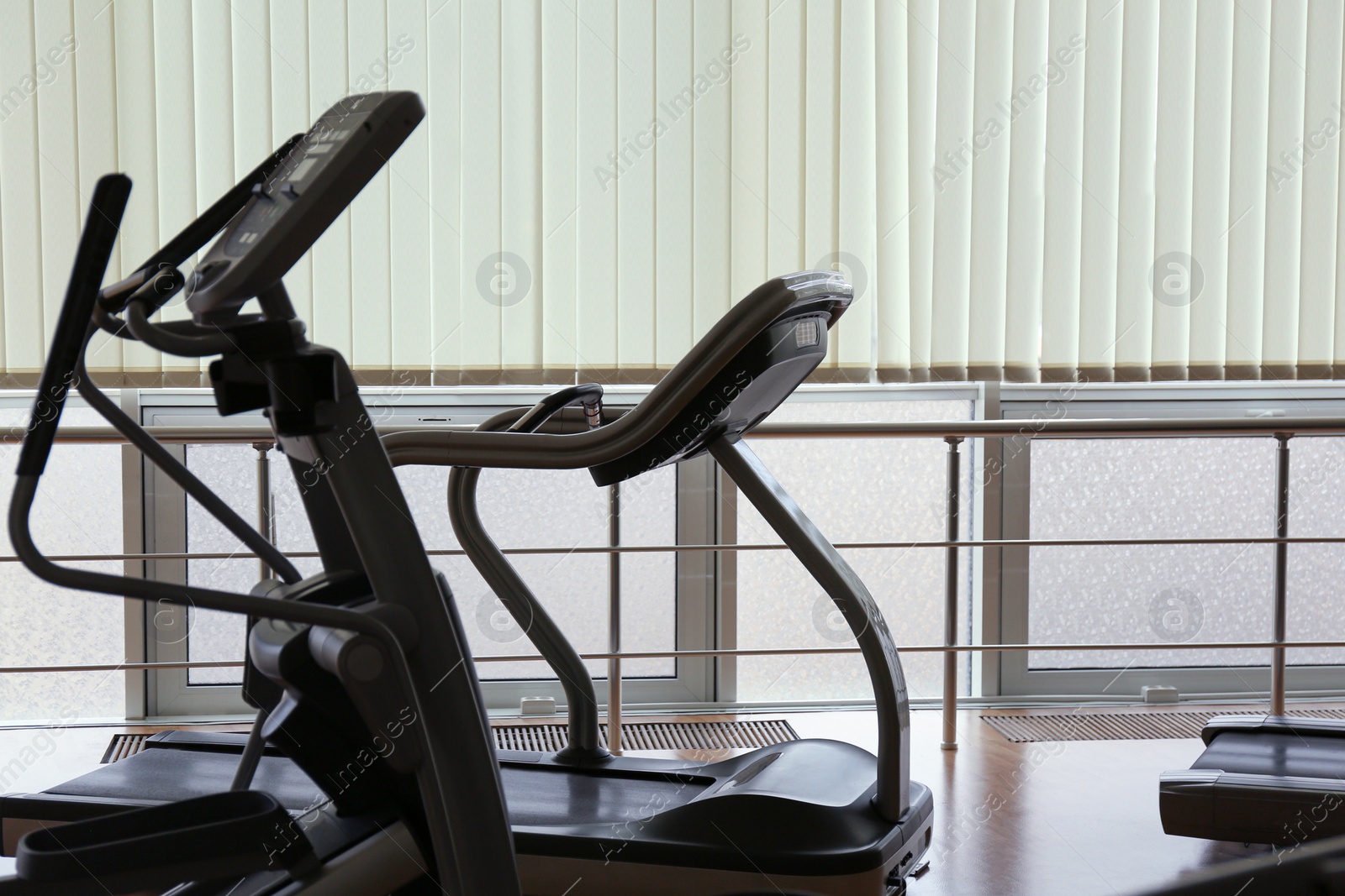 Photo of Elliptical trainer and treadmill in gym. Modern sport equipment