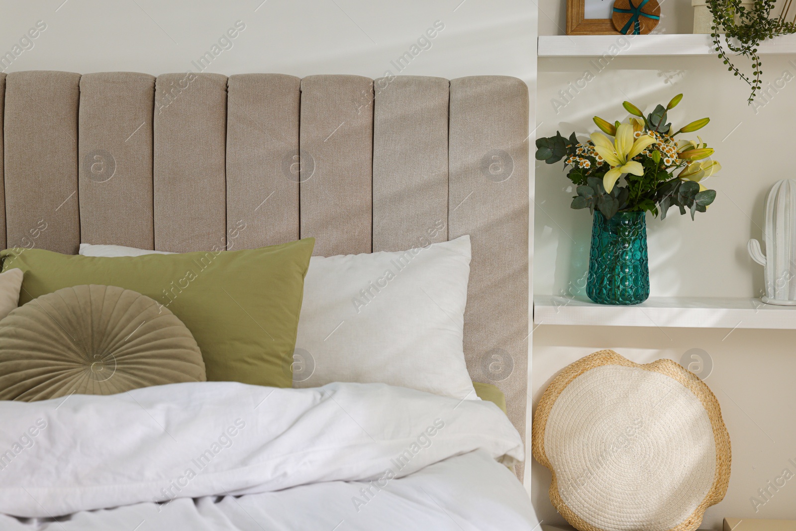 Photo of Bouquet of beautiful flowers and decor on shelf in bedroom