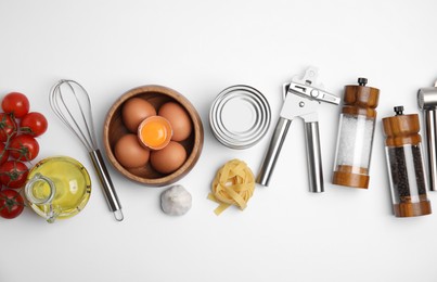 Cooking utensils and ingredients on white background, top view