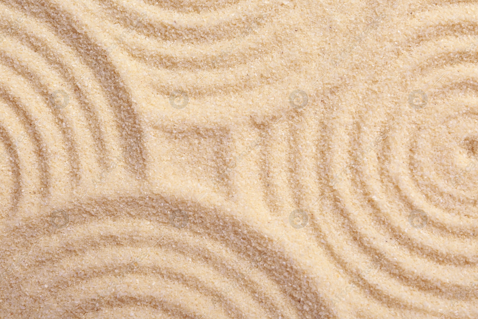 Photo of Zen rock garden. Circle patterns on beige sand, top view