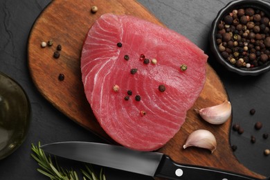 Raw tuna fillet and spices on black table, flat lay