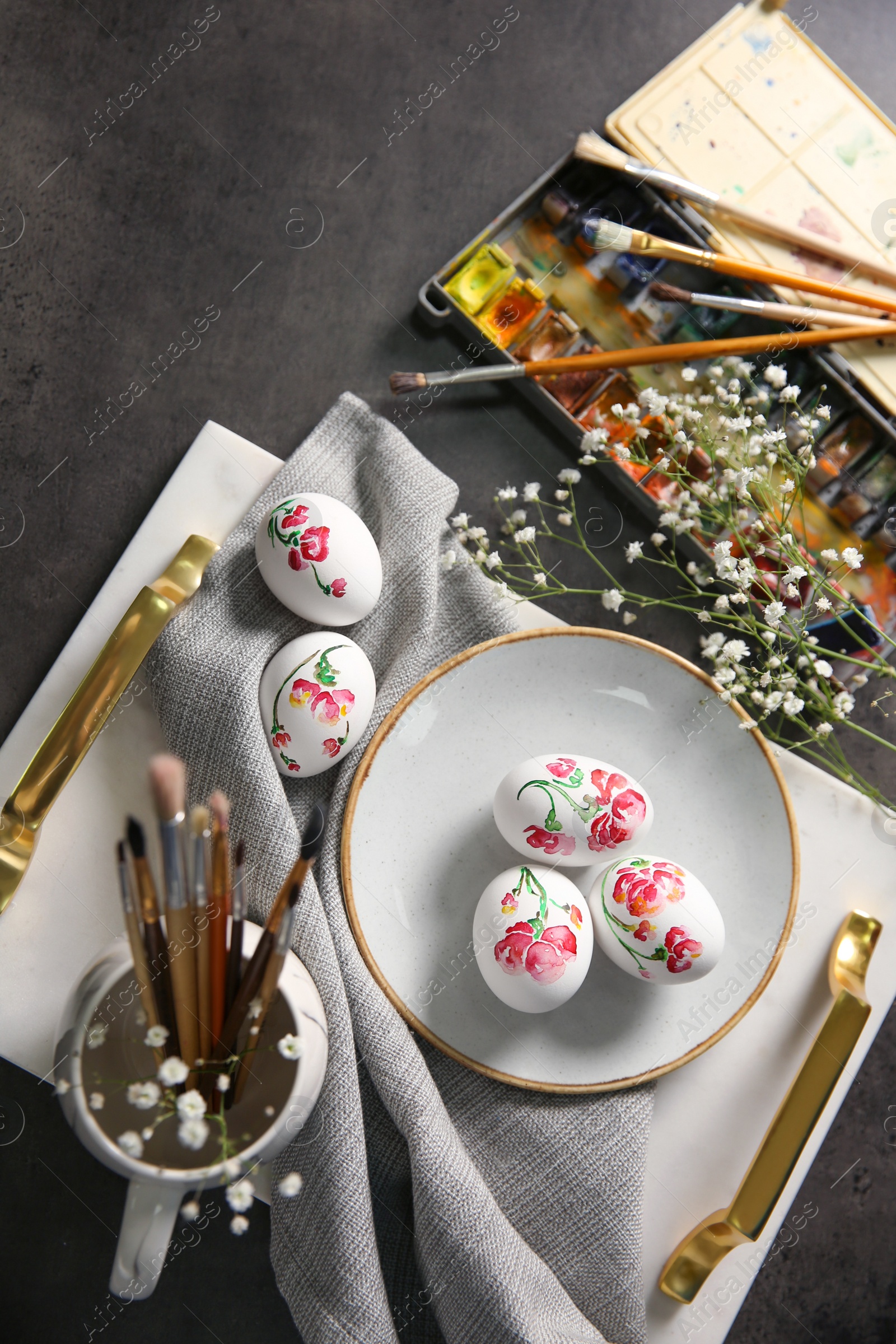 Photo of Flat lay composition with painted Easter eggs on dark table