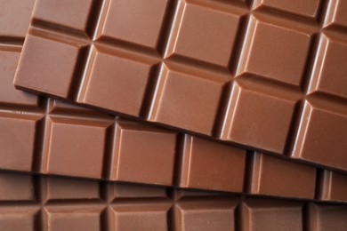 Delicious milk chocolate bars as background, top view