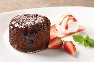 Delicious fresh fondant with hot chocolate, ice cream and strawberry served on plate. Lava cake recipe