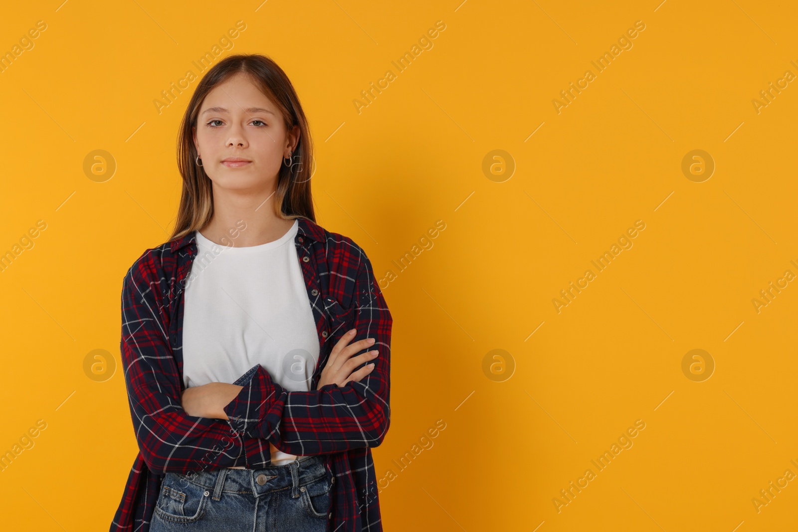 Photo of Portrait of beautiful teenage girl on orange background. Space for text