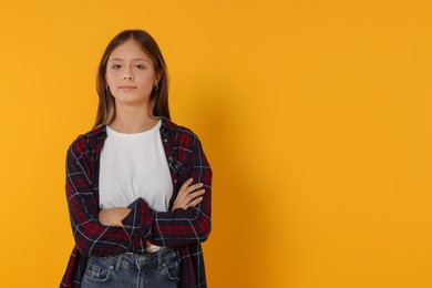 Portrait of beautiful teenage girl on orange background. Space for text