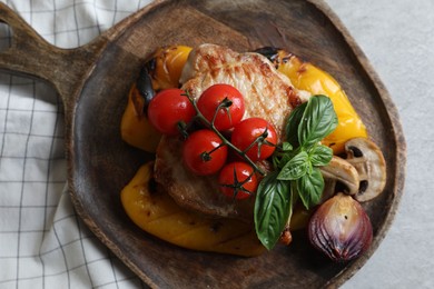 Photo of Serving board with tasty grilled meat and vegetables on light table, top view