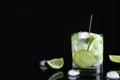 Photo of Delicious mojito and ingredients on black background. Space for text