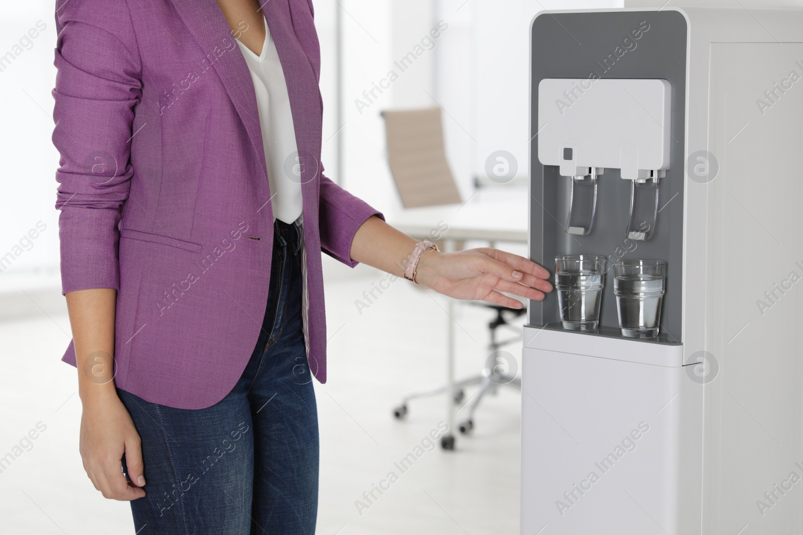 Photo of Woman taking glass of water from cooler in office, closeup