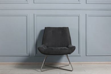 Photo of Comfortable armchair near grey wall in room