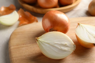 Photo of Whole and cut onions on table, closeup