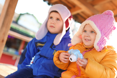 Cute children with toy camera outdoors. Future photographers