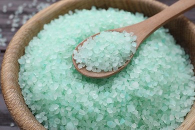 Photo of Spoon and turquoise sea salt in wooden bowl, closeup