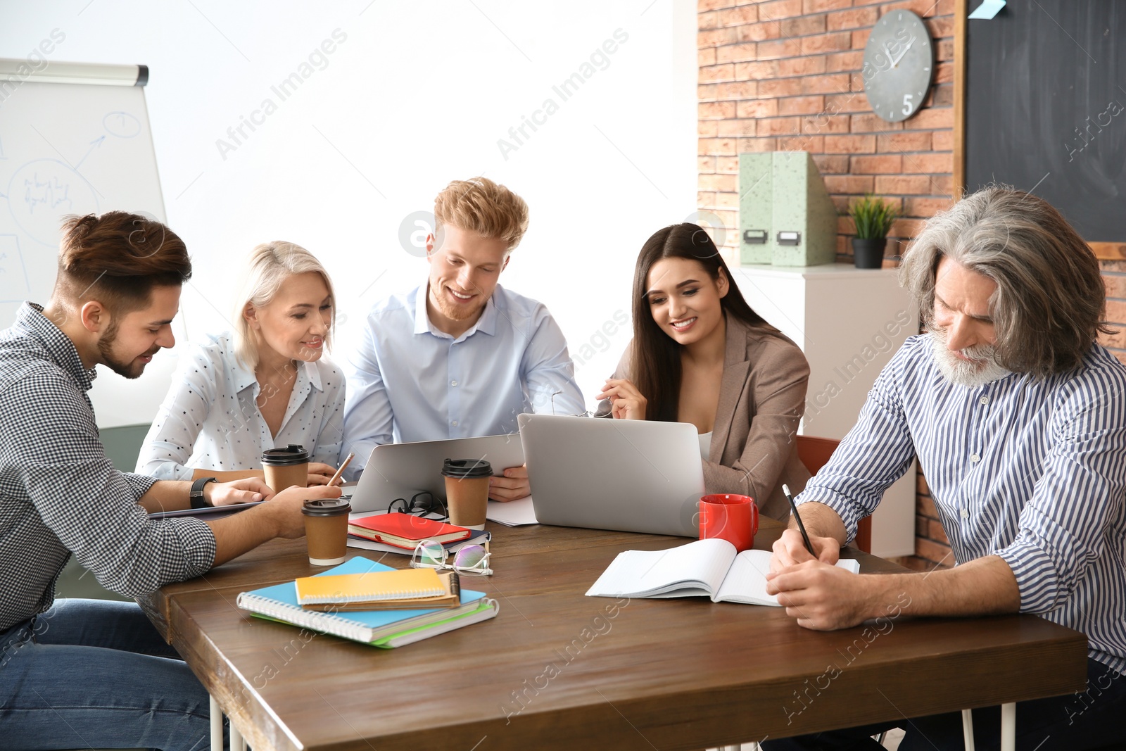 Photo of Business people discussing work matters at table in office. Professional communication