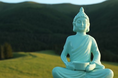 Decorative Buddha statue in mountains, closeup. Space for text