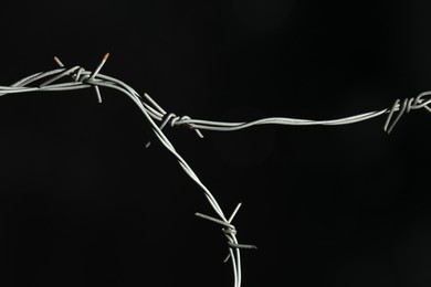 Photo of Shiny metal barbed wire on black background