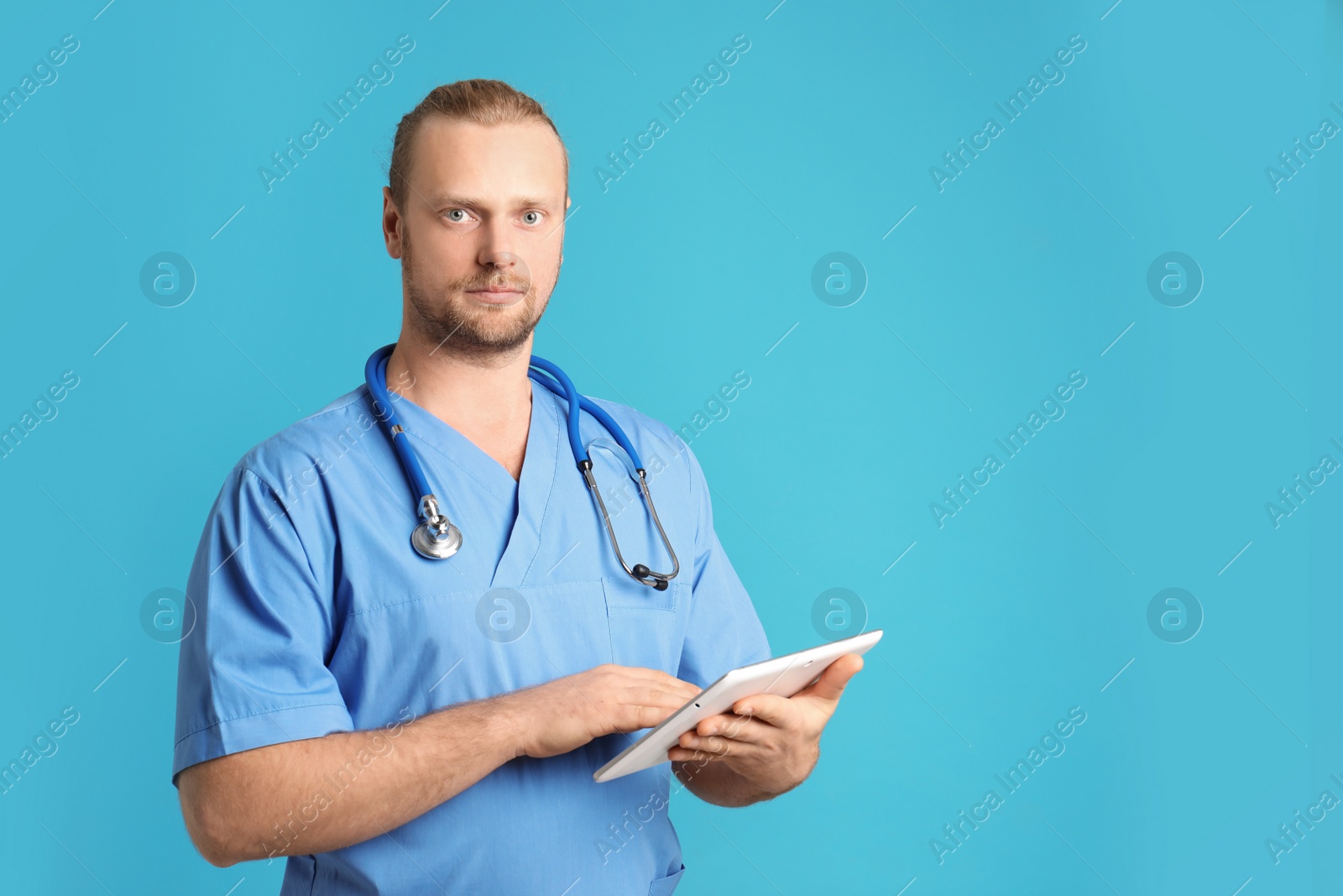 Photo of Portrait of medical assistant with stethoscope and tablet on color background. Space for text