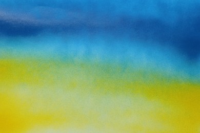 Photo of Abstract picture drawn by blue and yellow spray paints as background, closeup