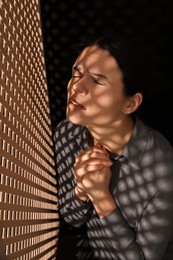 Woman praying to God during confession in booth