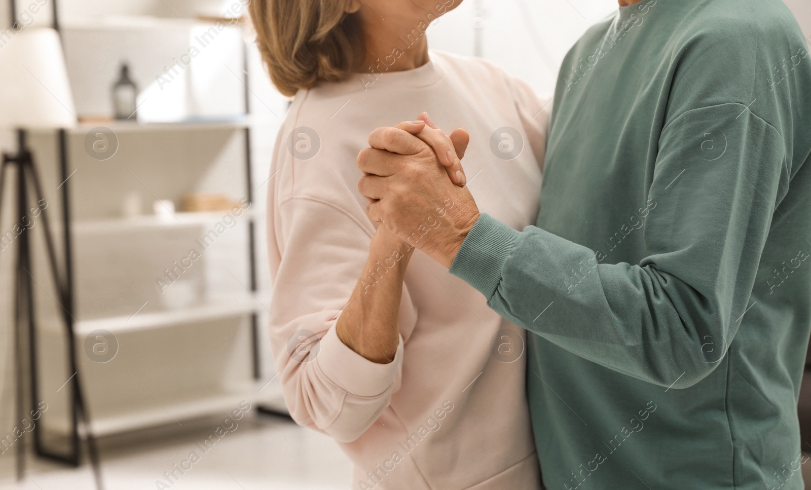 Photo of Happy senior couple dancing together at home, closeup