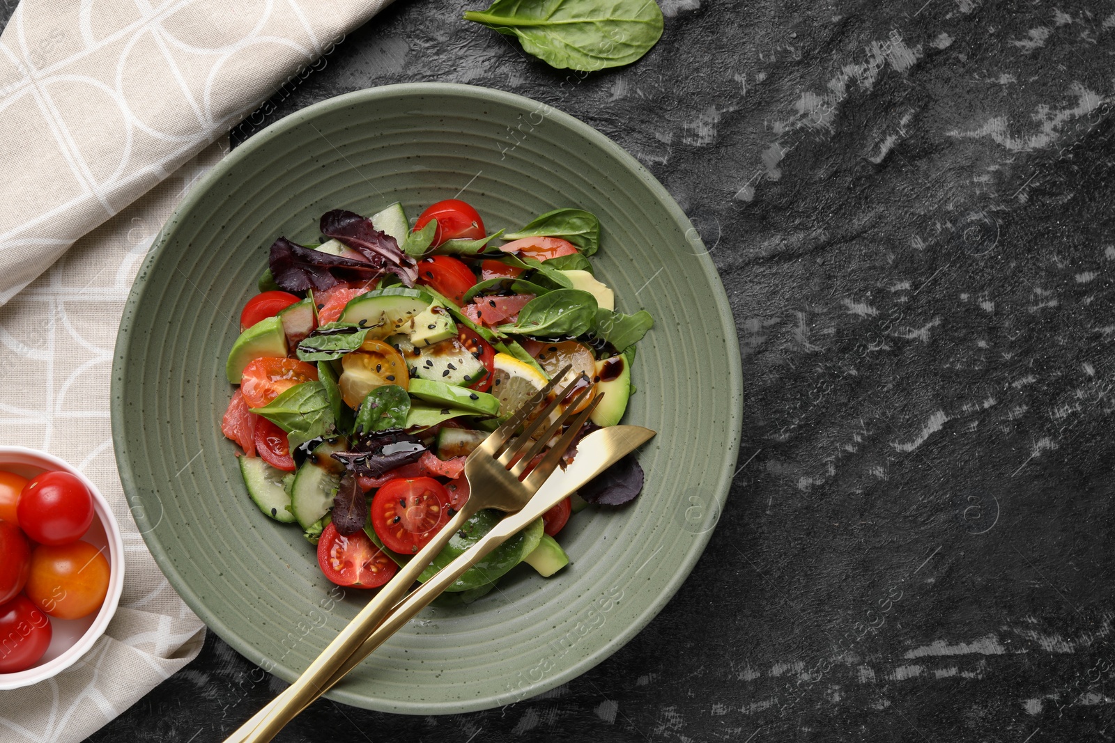 Photo of Delicious vegetable salad served on black textured table, flat lay. Space for text