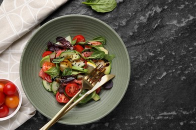 Photo of Delicious vegetable salad served on black textured table, flat lay. Space for text