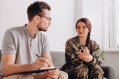 Photo of Female military officer talking with psychologist in office