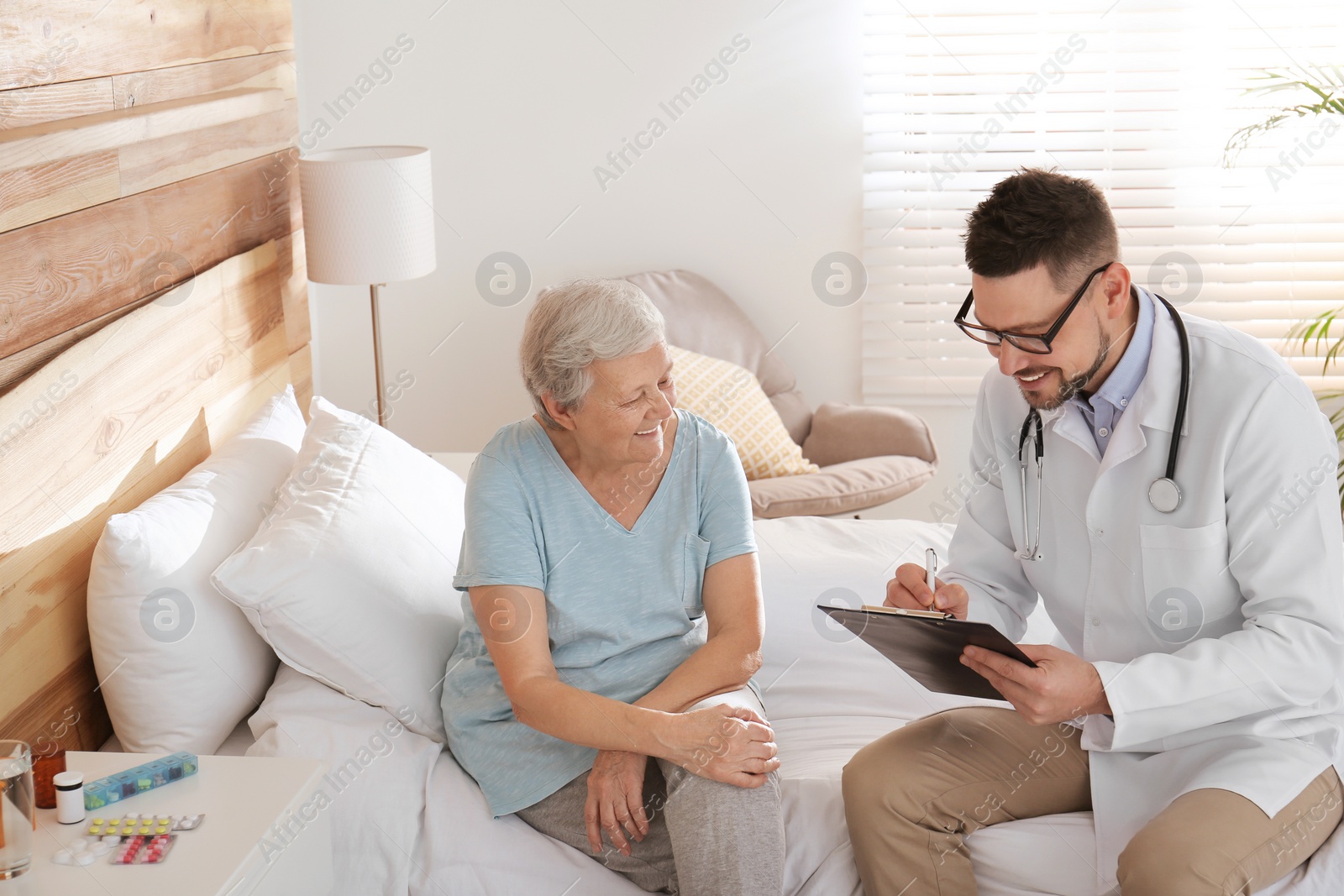 Photo of Doctor examining senior patient in modern hospital