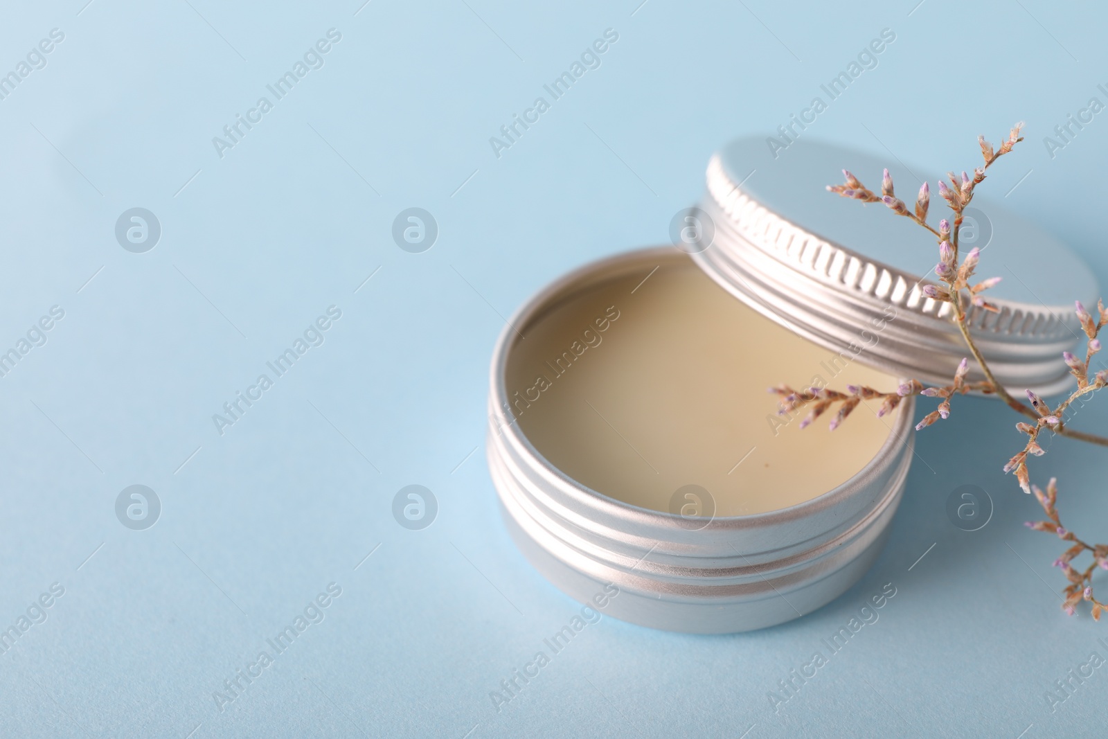 Photo of Lip balm on light blue background, space for text