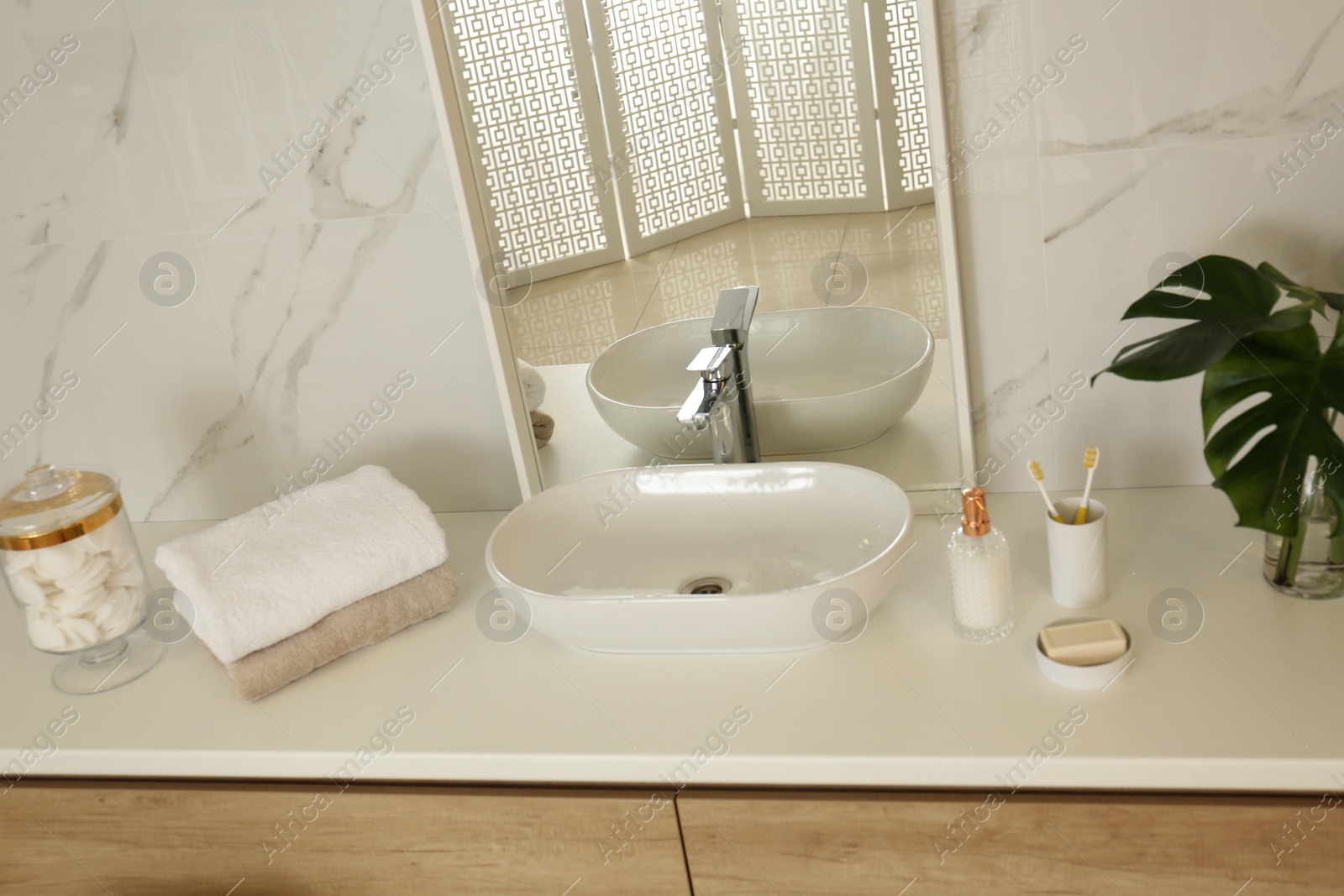 Photo of Large mirror and vessel sink in stylish bathroom