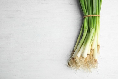 Fresh green onion on wooden table, top view