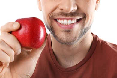 Photo of Smiling man with perfect teeth and red apple on white background, closeup