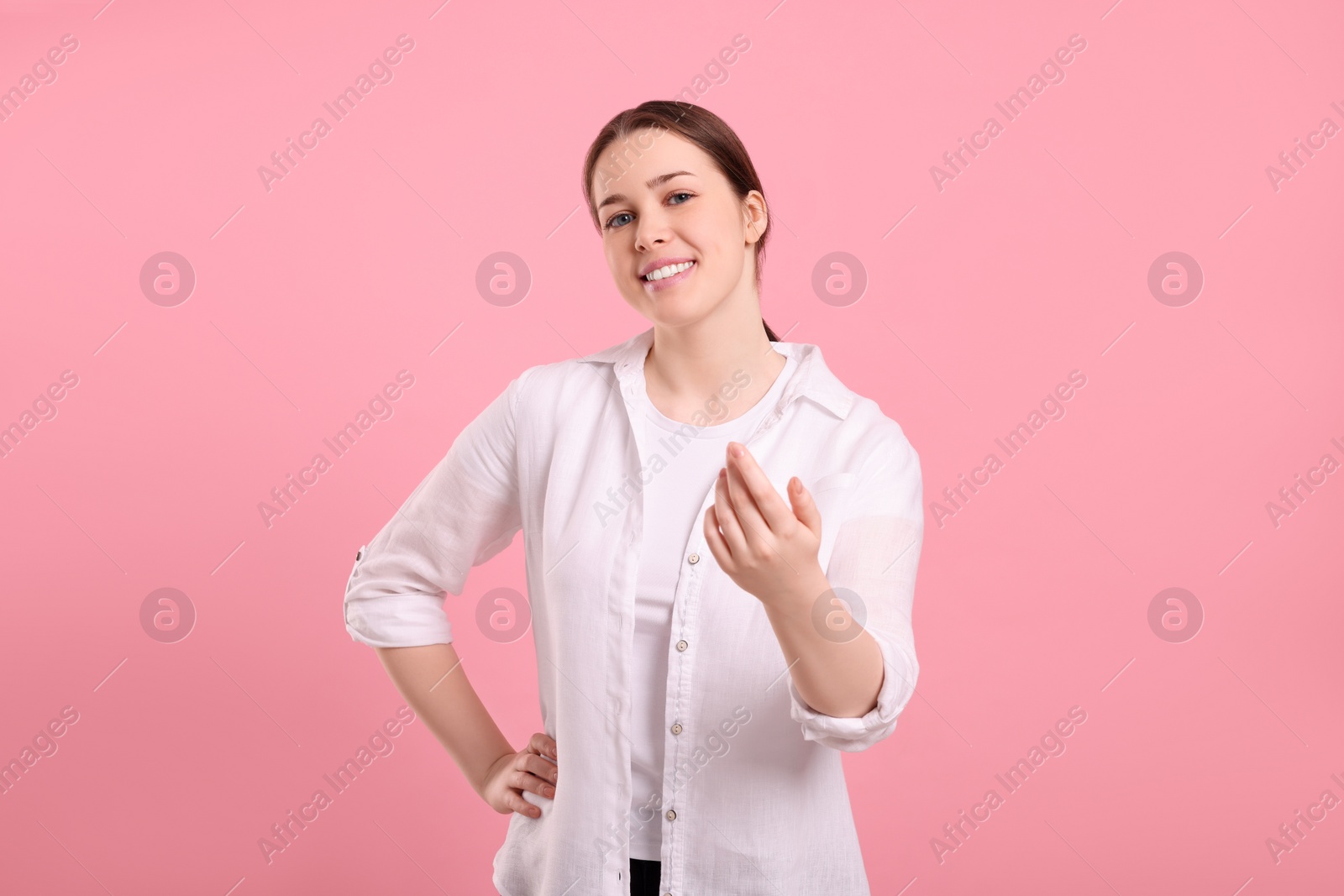 Photo of Happy woman inviting to come in on pink background