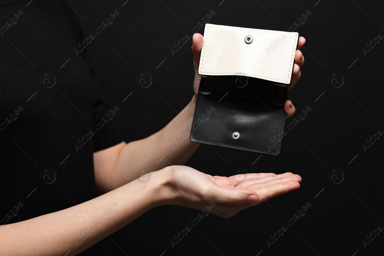 Photo of Woman with empty wallet on black background, closeup