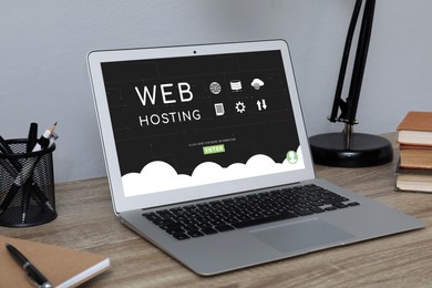 Image of Web hosting service. Comfortable workplace with modern laptop on wooden table