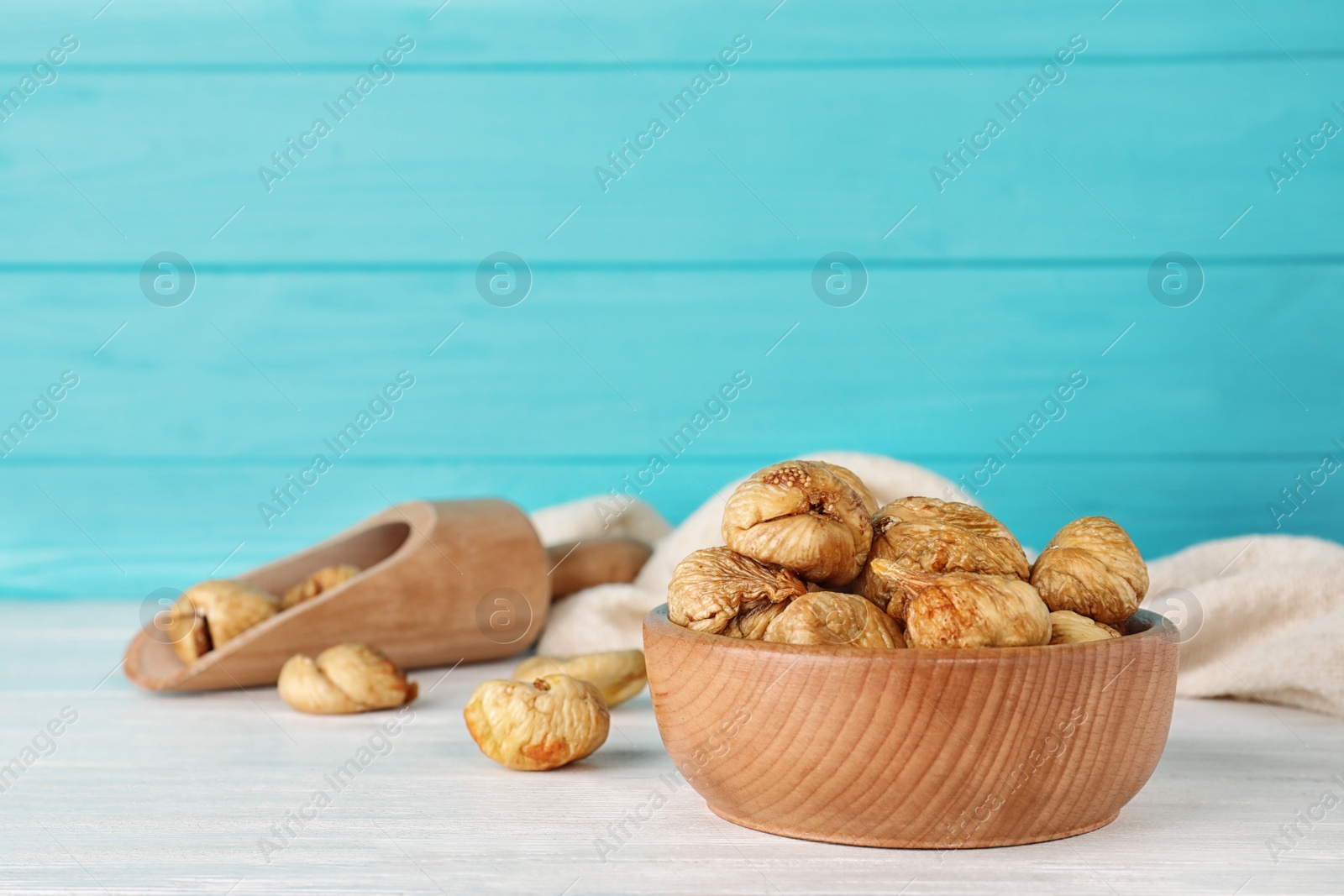 Photo of Wooden bowl with dried figs on table, space for text. Healthy fruit