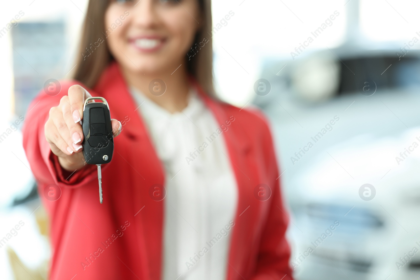 Photo of Young woman holding car key in salon