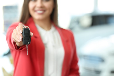 Photo of Young woman holding car key in salon
