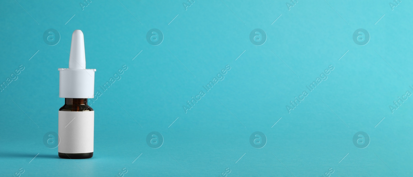 Photo of Bottle of nasal spray on light blue background, space for text