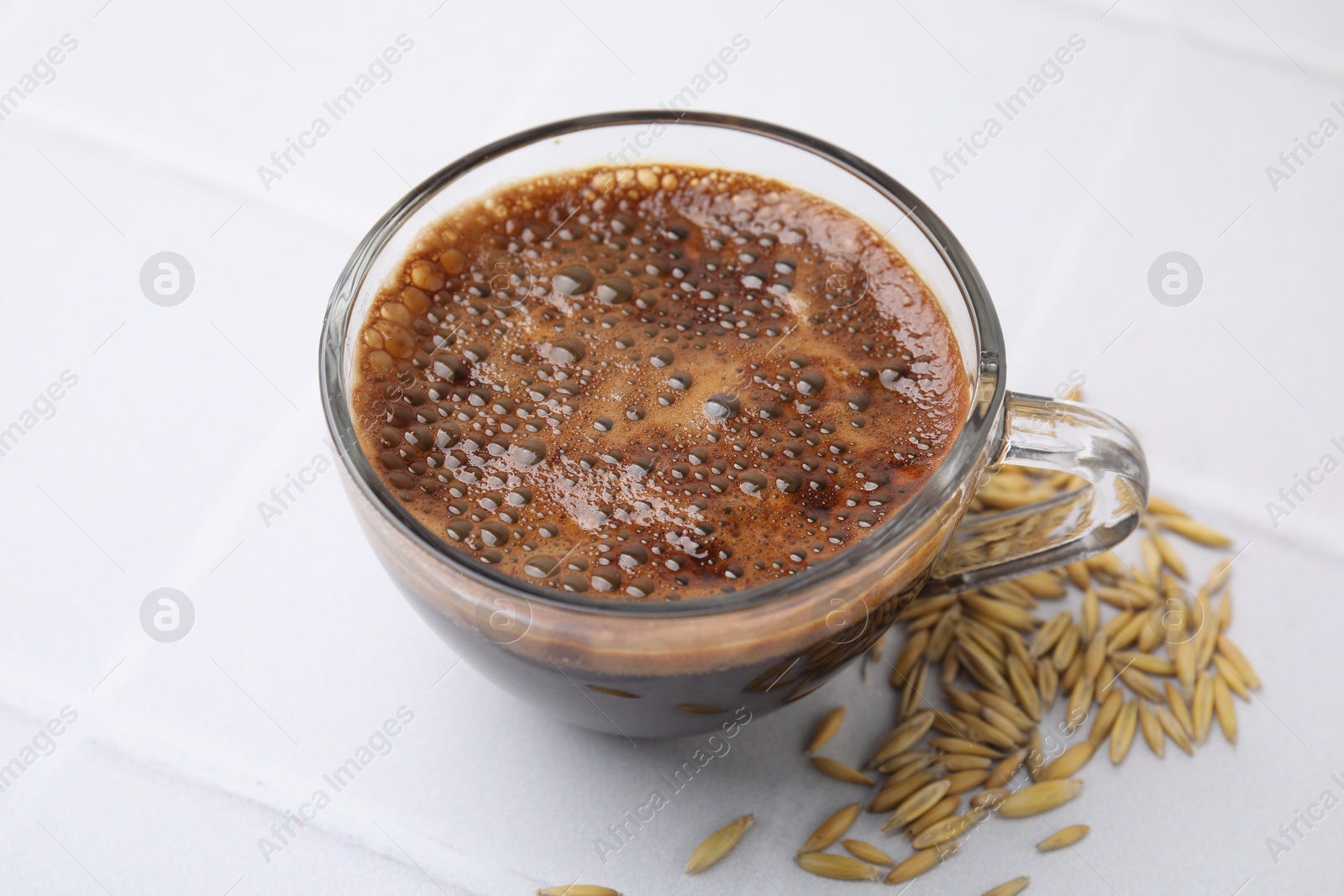 Photo of Cup of barley coffee and grains isolated on white, closeup