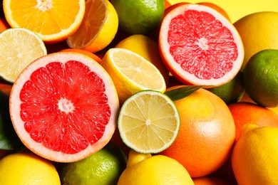 Different fresh citrus fruits as background, closeup