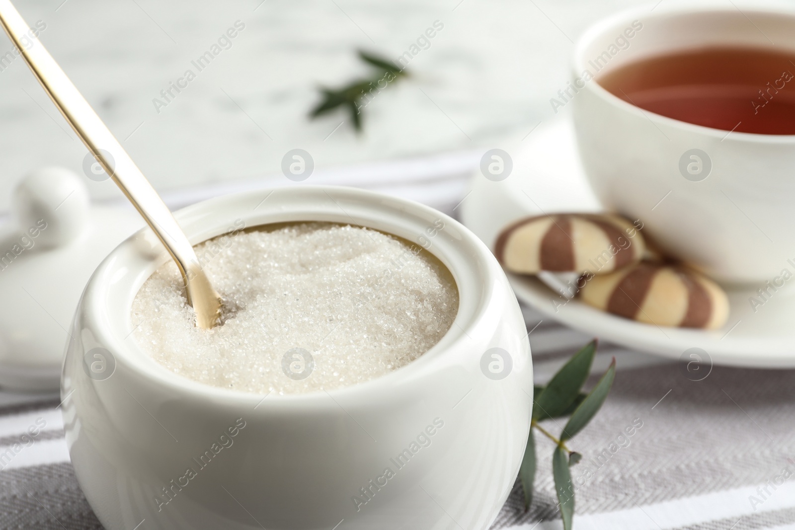 Photo of Granulated sugar in bowl on table, closeup