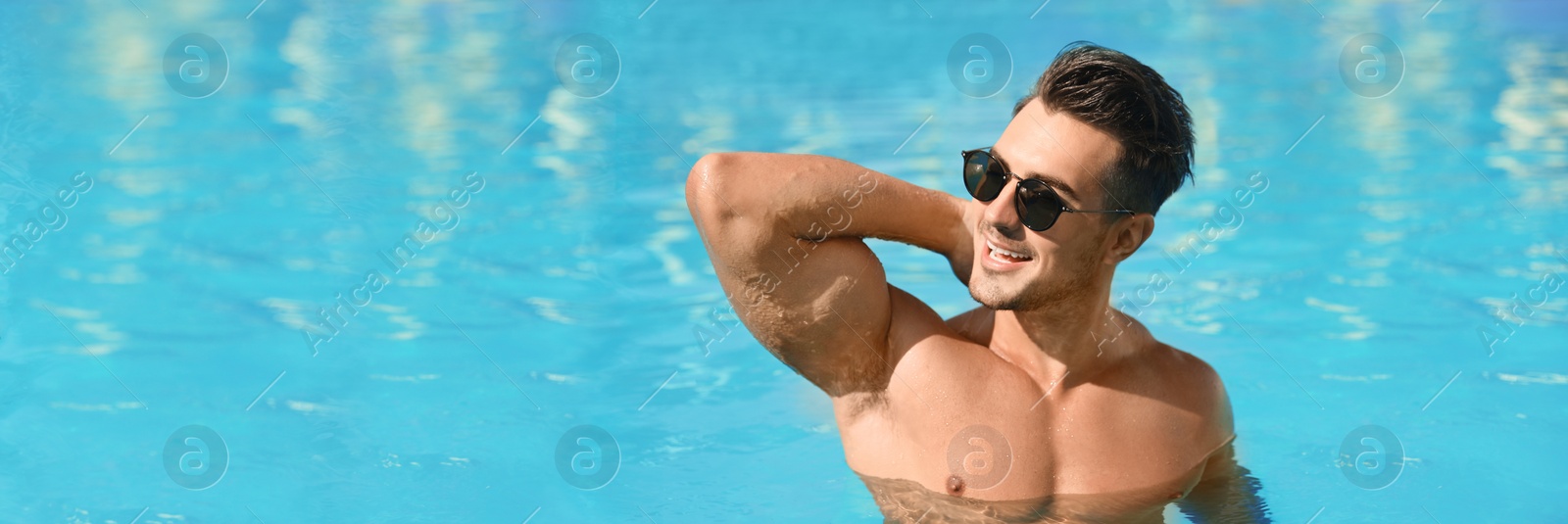 Image of Handsome man in swimming pool on sunny day, space for text. Banner design