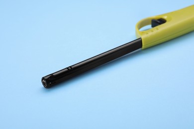 One gas lighter on light blue background, closeup