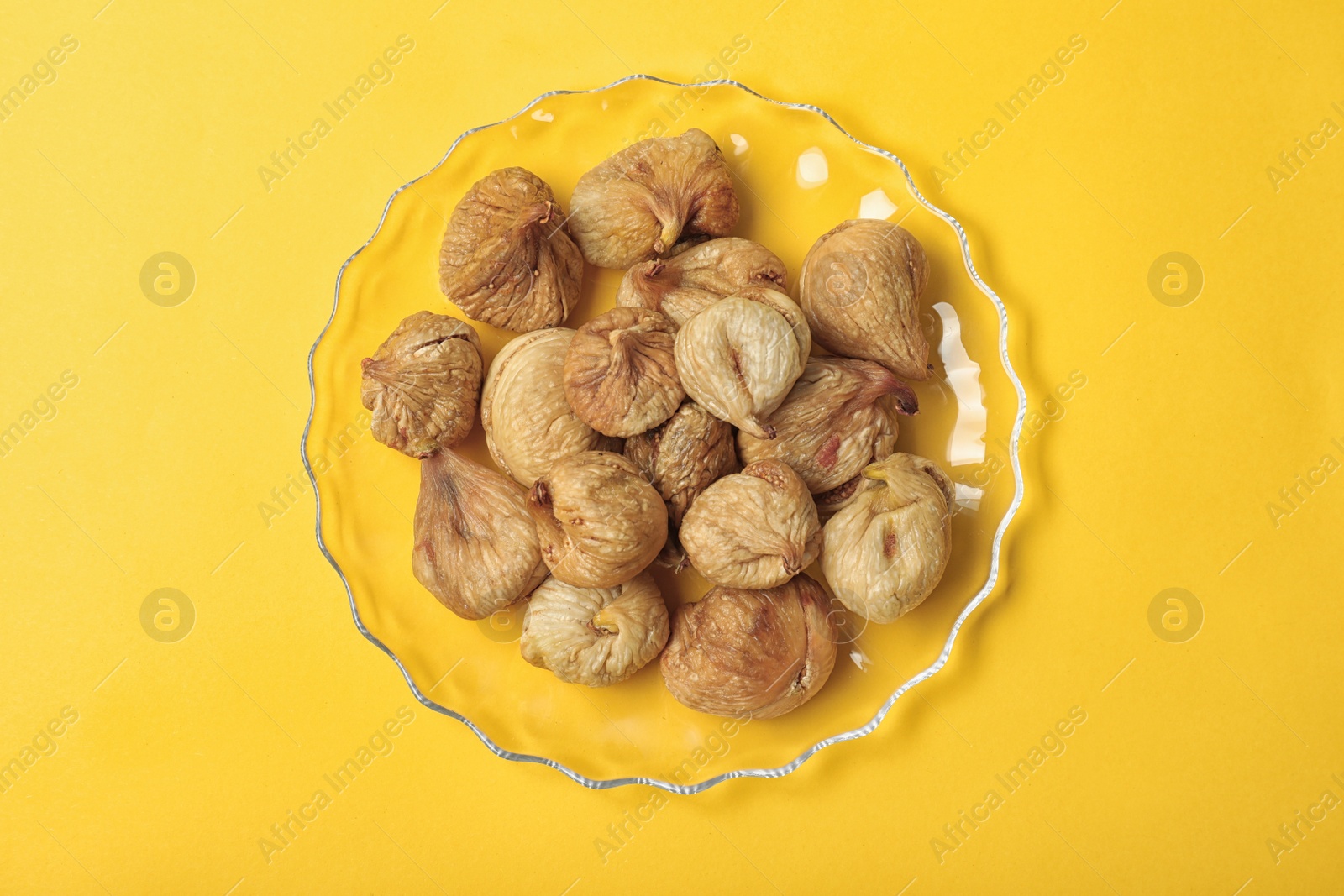 Photo of Plate with dried figs on color background, top view. Healthy fruit