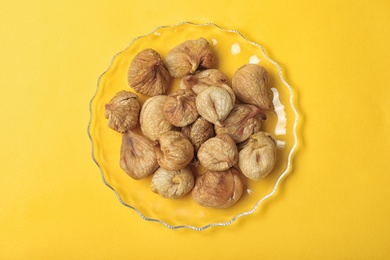 Photo of Plate with dried figs on color background, top view. Healthy fruit