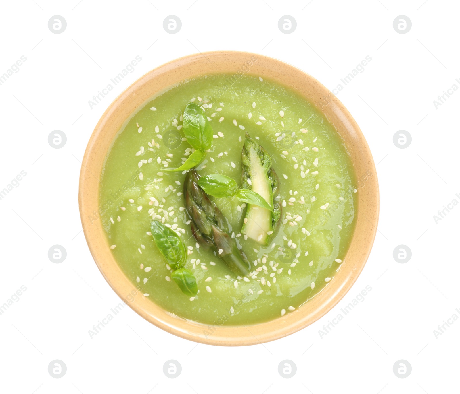 Photo of Delicious asparagus soup with basil and sesame seeds isolated on white, top view