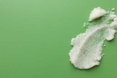 Photo of Sample of body scrub on green background, top view. Space for text