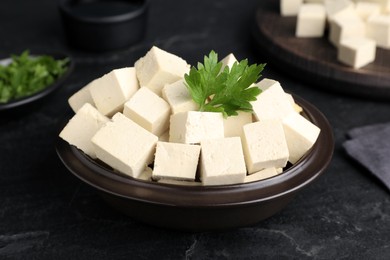 Photo of Delicious tofu with parsley on black table, closeup